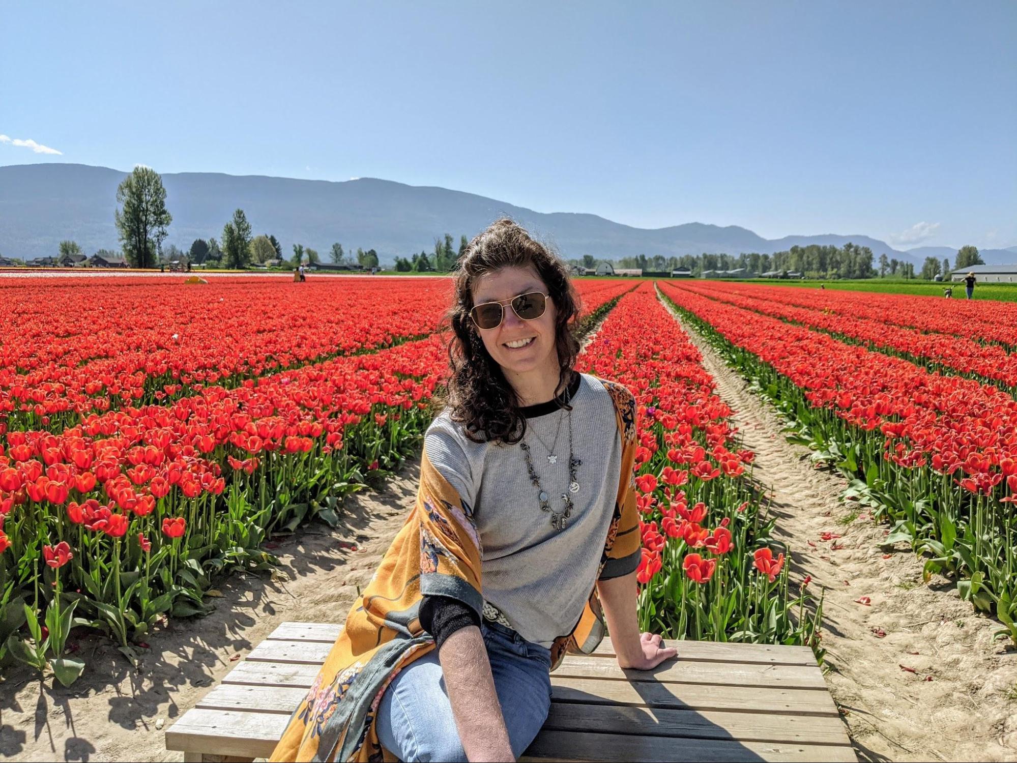 Mel and tulips Mel sitting on a bench in a field of red tulips at the Chilliwack tulip festival