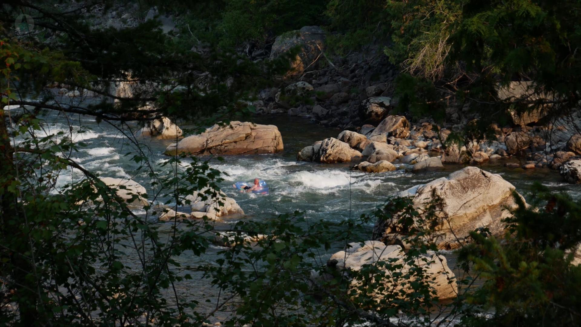 Rivier Floating on the Similkameen River A person riding the small rapids on the Similkameen River from the comfort of a water floaty at Old Hedley West Recreation Site.